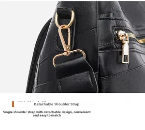 Detail showing the detachable shoulder strap with golden metal clasp and black leather texture