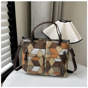 Detail of multi-texture patchwork tote bag with crocodile and lychee leather patterns