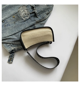 Détail du sac tressé avec bordure noire et bandoulière à œillets métalliques