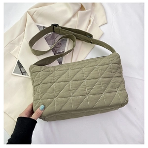 Detail view of the green quilted dumpling bag with adjustable shoulder strap and stitching