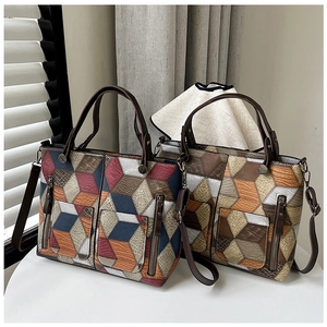 Detail view of large tote bag featuring 3D geometric patchwork and textured leather
