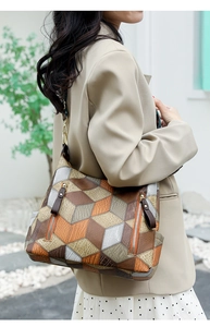 Close-up of geometric 3D pattern and side zipper detail on luxury leather tote bag