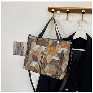 Detail view of 3D geometric patchwork tote bag with textured faux leather and zip pockets