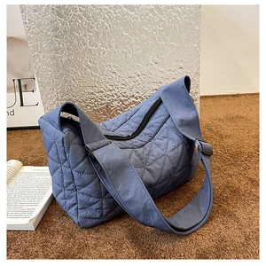 Detailed close-up of the blue quilted rhombic stitching and matte fabric texture
