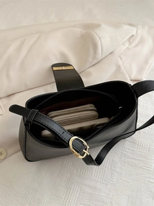 Minimalist black baguette shoulder bag with gold hardware and spacious interior view