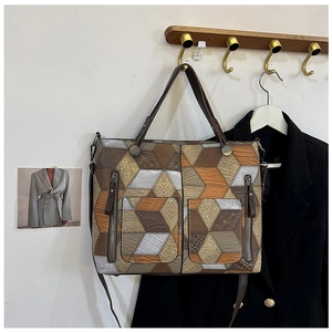 Detailed view of geometric leather tote bag featuring 3D patchwork and crocodile texture