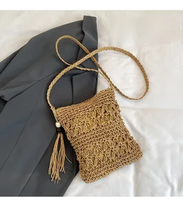 Detailed view of handmade woven hollow shoulder bag with bohemian fringe and wooden beads
