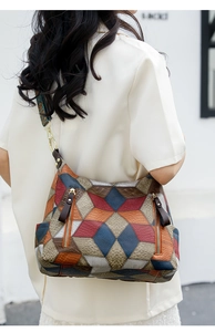 Detail view of vintage multi-color patchwork shoulder bag with wide printed strap and gold hardware