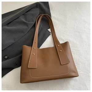Detailaufnahme der braunen Shopper-Tasche mit Kontrastnähten und metallischen Nieten