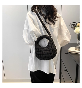 Detail showing the quilted bubble texture and adjustable strap of this black mini tote bag