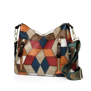 Detail view of colorful patchwork hobo bag with ethnic style strap and gold zippers
