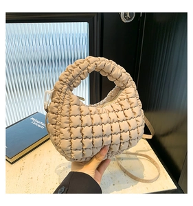Detail view of apricot quilted mini tote bag with ruched handle and zip closure