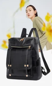 Close-up of black patchwork faux leather backpack with distinctive gold metal H-buckles