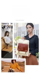 Detail of a two-tone beige and brown leather backpack with buckle flap and zipper closure