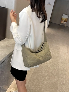 Green quilted dumpling crossbody bag with large capacity shown on female model in stylish setting