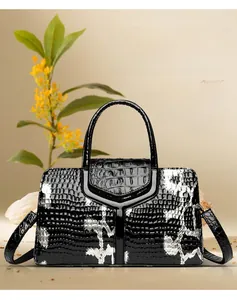 Macro shot of black crocodile embossed cowhide texture on stylish women's tote handbag