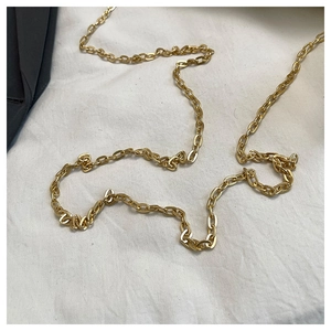 Detail of chunky gold metal chain strap for a fashion shoulder bag with metallic luster