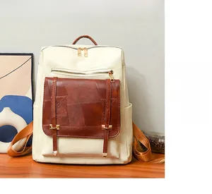 Detail of elegant two-tone faux leather backpack with gold zipper on wooden table