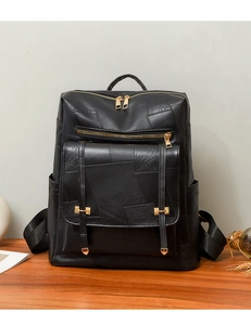 Detailed close-up of black textured backpack with golden hardware and zipper detail