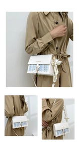Detail of tweed and white leather crossbody bag with gold chain and silk bow