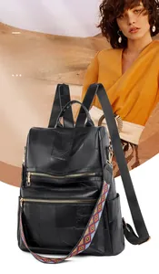 Detail of black faux leather backpack featuring vintage textures and colorful ethnic strap