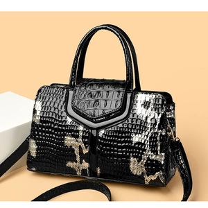 Macro view of polished snake pattern handbag showing luxurious V-flap and thick handles