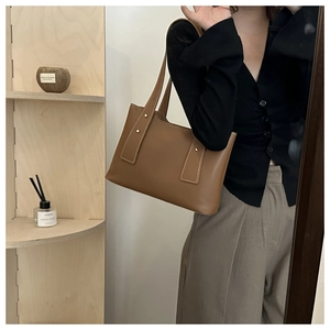 Detail der karamellfarbenen Leder-Tote Bag mit Goldnieten und feinen Nähten im Lifestyle-Look