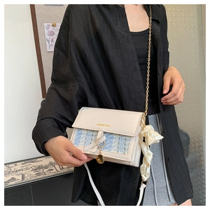 Detail of tweed and cream leather shoulder bag with gold chain and silk scrunchie accessory