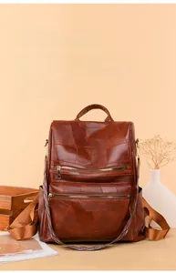 Close-up of vintage brown leather backpack with ethnic style embroidered strap and zipper details