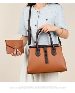 Close-up of brown lychee grain handbag with matching envelope wallet held by model