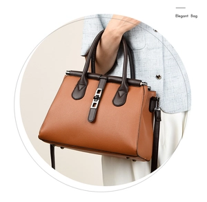 Close-up of caramel lychee grain leather handbag with silver lock and brown handle