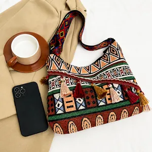 Detailed view of ethnic shoulder bag featuring geometric patterns and colorful tassels