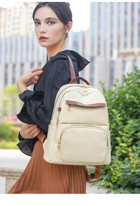 Detail view of cream PU leather backpack with geometric stitching and brown straps