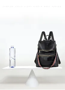 Detail of lightweight 0.5kg black plaid leather backpack with colorful geometric strap