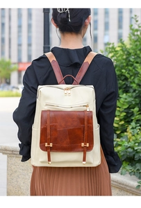 Close-up of stylish patchwork backpack featuring leather textures and golden zipper details