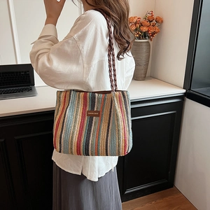 Détail du sac cabas en paille tissée à rayures multicolores avec étiquette en cuir