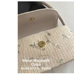 Close-up of golden magnetic snap button on floral embroidered beige knit handbag