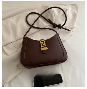 Gros plan du sac en croissant avec fermoir doré et bandoulière en cuir près d'un mobile