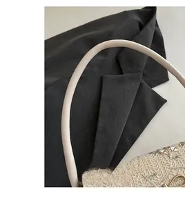 Detail of cream baguette bag featuring textured crochet embroidery and soft handles