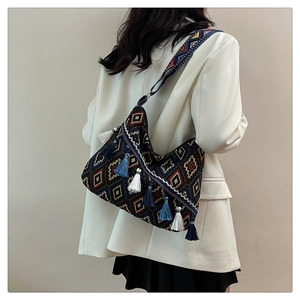 Detail of bohemian shoulder bag with geometric patterns and fringe tassels
