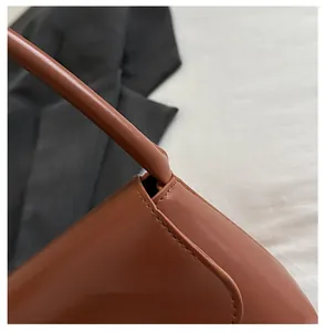 Detail shot of brown leather bag showing premium stitching and smooth matte texture