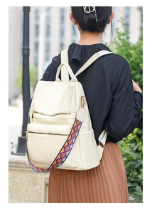 Detail of cream white textured backpack with colorful ethnic woven shoulder strap