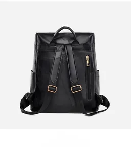 Rear view of black leather backpack featuring patchwork texture and golden zipper detail