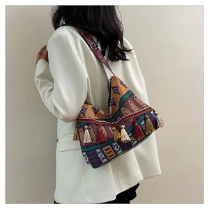 Detail of ethnic jacquard shoulder bag with colorful tassels and patterned strap