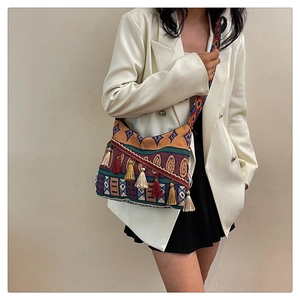 Detailed shot of ethnic style crossbody bag with colorful jacquard patterns and tassels