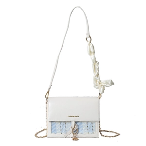 White and blue tweed flap bag with gold chain and silk bow detail on white background