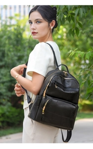 Detail of black patchwork soft leather backpack with gold zippers shown on a model
