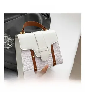 Detalle del bolso de cuero blanco perla con textura geométrica y remaches dorados