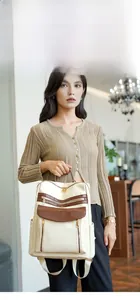 Détail du sac à dos en similicuir crème et marron avec texture croco et zips