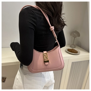 Détail du sac croissant rose avec boucle dorée en G et nœud décoratif sur l'anse